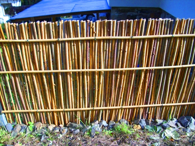 Senkrechter Weidenzaun mit Weiden zwischen 6 Bambusstangen, dicht an dicht gesetzt